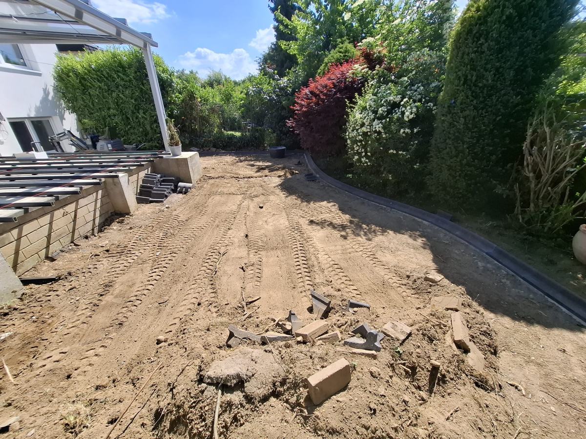 Ausgekofferte und planierte Gartenfläche mit Randstreifen entlang der Hecke