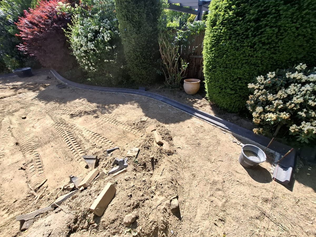 Vorbereitete Erdfläche vor dem Rollrasen, Randsteine entlang der Bepflanzung