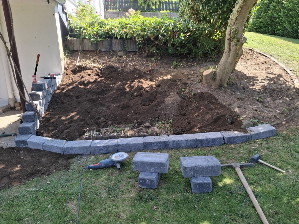 Bauphase: Steine für die Einfassung werden in Beton gesetzt, Beet noch ohne Bepflanzung
