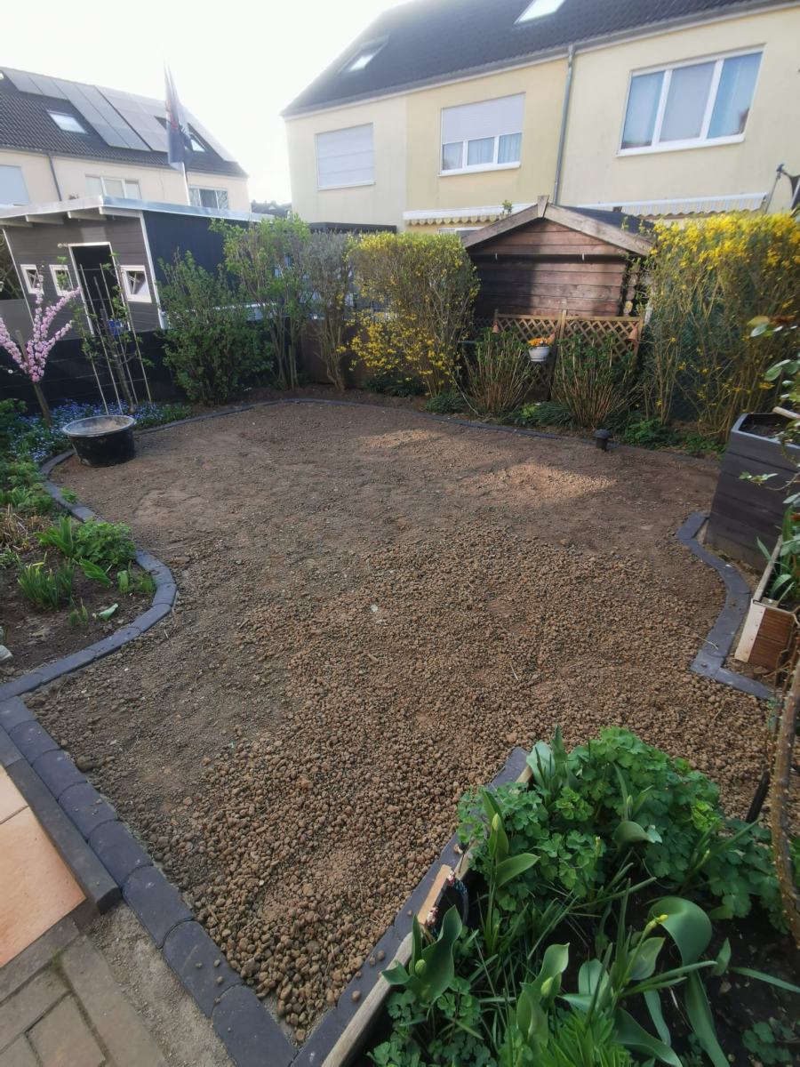 Vorbereitete Fläche mit Randsteinen vor dem Verlegen des Rollrasens